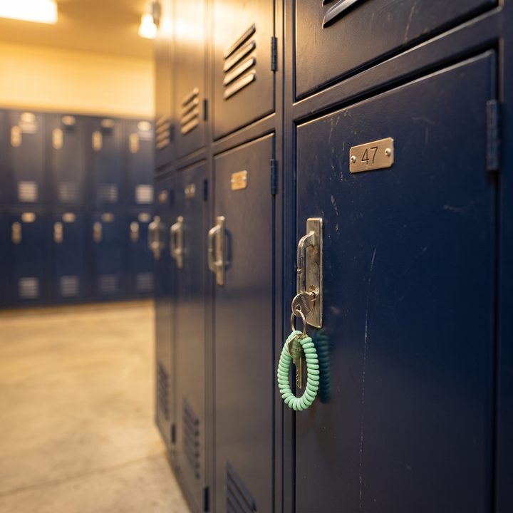 A navy gym locker numbered 47 with a key on a wristband